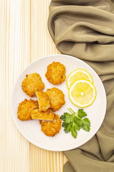 Pasteles caseros de pescado rojo con limón y perejil en plato de cerámica. Con cortinas de tela sobre fondo de madera, de cerca, vista superior . — Foto de Stock