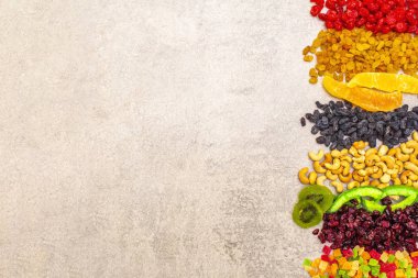 Kurutulmuş ve şekerli meyve ve fındık. Taş zeminde çeşitlendirilmiş. Sağlıklı vejetaryen (vejetaryen) gıda konsepti, kopyalama alanı, üst görünüm.
