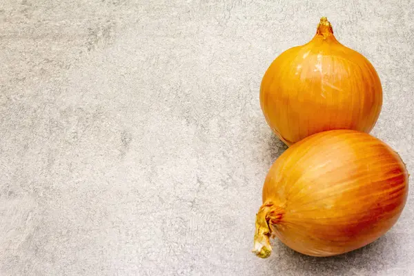 Bolbos de cebola gigantes em um fundo de pedra. Comida cozinha fundo, espaço de cópia . — Fotografia de Stock