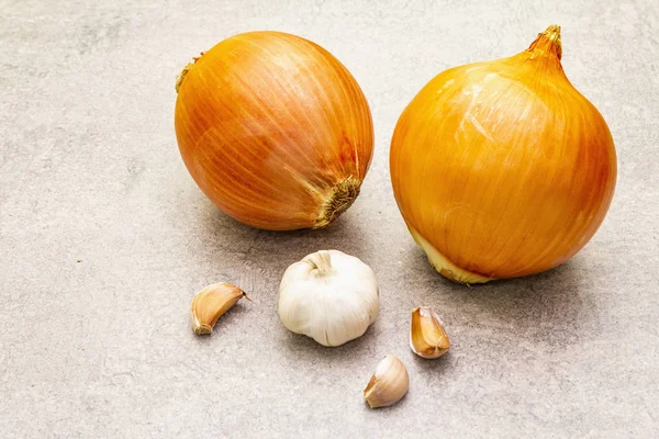 Lâmpadas de cebola gigantes com alho da escala em um contexto de pedra. Alimentos cozinha fundo, close-up . — Fotografia de Stock