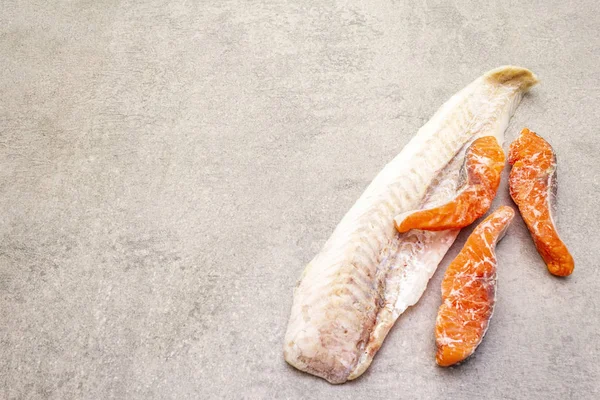 冷凍魚の盛り合わせだフィレとサーモンの部分を焼く。健康的な料理のための成分。石料理の背景、コピースペース. — ストック写真