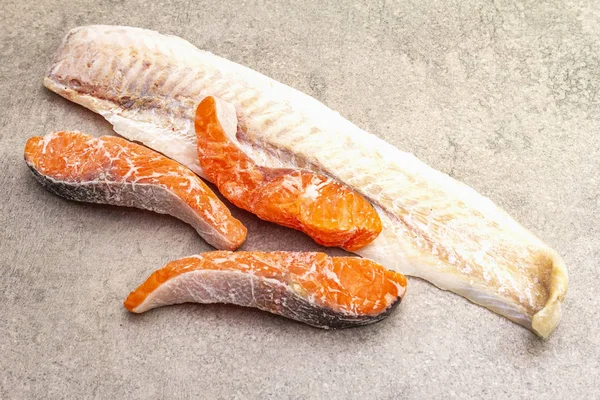 Pesce surgelato assortito. Filetto di nasello e pezzi di salmone. Ingredienti per una cucina sana. Pietra sfondo culinario, spazio copia . — Foto Stock