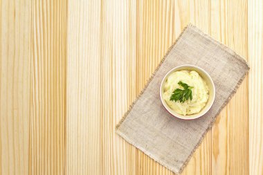 Seramik kasede taze maydanozlu patates püresi. Kaliteli keten peçeteye taş zemin, üst görünüm, boşluğu kopyala.