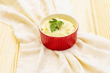 Seramik kasede taze maydanozlu patates püresi. Kaliteli keten bir peçeteye, taş bir arka planda, kopyala alanı, kapat.