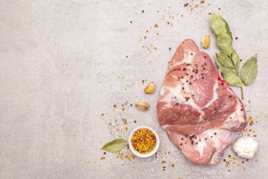 Çiğ domuz omuzu ve baharat. Saha yaprağı, sarımsak. Bir taş arkaplanda, boşluk kopyala, üst görünüm.