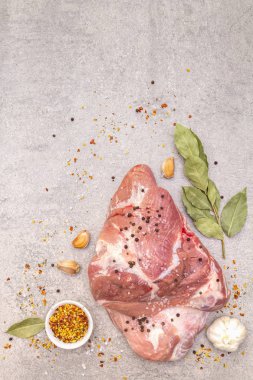 Çiğ domuz omuzu ve baharat. Saha yaprağı, sarımsak. Bir taş arkaplanda, boşluk kopyala, üst görünüm.