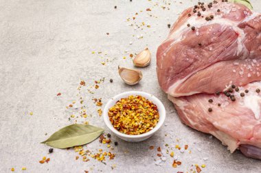 Çiğ domuz omuzu ve baharat. Saha yaprağı, sarımsak. Taş bir arkaplanda, boşluğu kopyala, kapat.