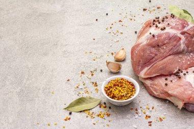 Çiğ domuz omuzu ve baharat. Saha yaprağı, sarımsak. Taş bir arkaplanda, boşluğu kopyala.