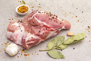 Çiğ domuz omuzu ve baharat. Saha yaprağı, sarımsak. Taş bir arka planda, kapat.