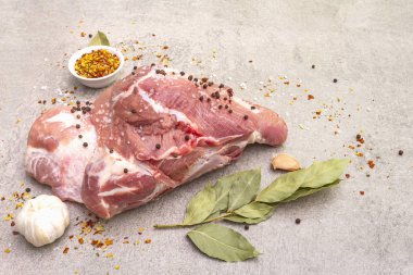 Çiğ domuz omuzu ve baharat. Saha yaprağı, sarımsak. Taş bir arka planda, kapat.