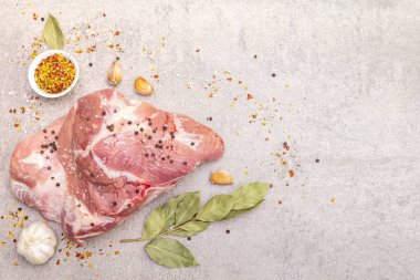 Çiğ domuz omuzu ve baharat. Saha yaprağı, sarımsak. Bir taş arkaplanda, boşluk kopyala, üst görünüm.