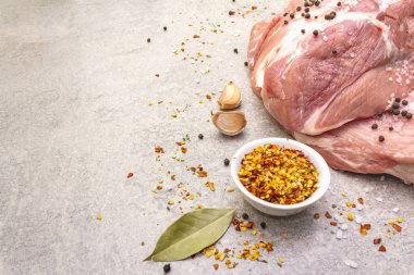 Çiğ domuz omuzu ve baharat. Saha yaprağı, sarımsak. Taş bir arkaplanda, boşluğu kopyala.