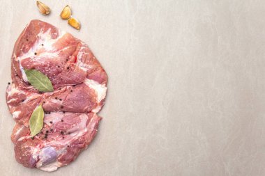 Çiğ domuz omuzu ve baharat. Saha yaprağı, sarımsak. Bir taş arkaplanda, boşluk kopyala, üst görünüm.