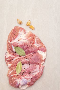 Çiğ domuz omuzu ve baharat. Saha yaprağı, sarımsak. Bir taş arkaplanda, boşluk kopyala, üst görünüm.