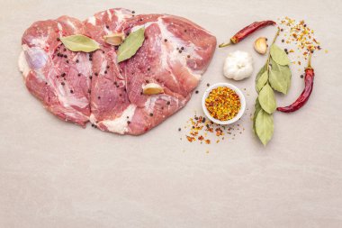 Çiğ domuz omuzu ve baharat. Saha yaprağı, sarımsak. Bir taş arkaplanda, boşluk kopyala, üst görünüm.