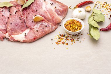 Çiğ domuz omuzu ve baharat. Saha yaprağı, sarımsak. Taş bir arkaplanda, boşluğu kopyala.