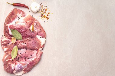 Çiğ domuz omuzu ve baharat. Saha yaprağı, sarımsak. Bir taş arkaplanda, boşluk kopyala, üst görünüm.