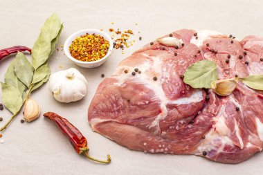 Çiğ domuz omuzu ve baharat. Saha yaprağı, sarımsak. Taş bir arka planda, kapat.