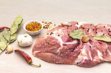 Çiğ domuz omuzu ve baharat. Saha yaprağı, sarımsak. Taş bir arka planda, kapat.