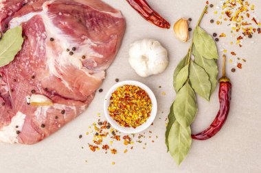 Çiğ domuz omuzu ve baharat. Saha yaprağı, sarımsak. Taştan bir arkaplanda, üst görünümü kapat..