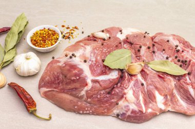 Çiğ domuz omuzu ve baharat. Saha yaprağı, sarımsak. Taş bir arka planda, kapat.