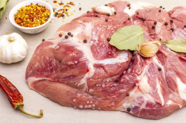 Çiğ domuz omuzu ve baharat. Saha yaprağı, sarımsak. Taş bir arka planda, kapat.