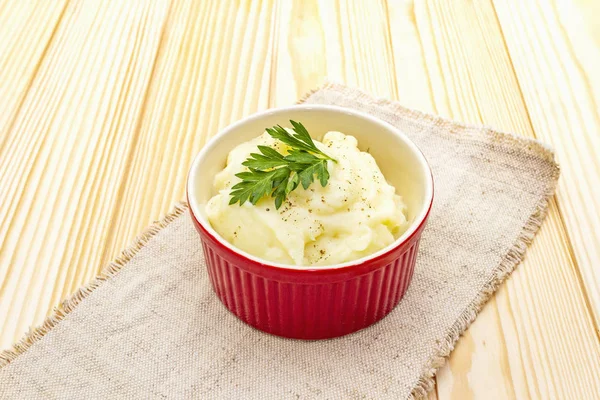 Warm mashed potatoes in a ceramic bowl with fresh parsley. On a vintage linen napkin on a stone background, close up. — Stock Photo, Image