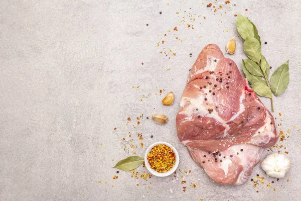 Çiğ domuz omuzu ve baharat. Saha yaprağı, sarımsak. Bir taş arkaplanda, boşluk kopyala, üst görünüm.