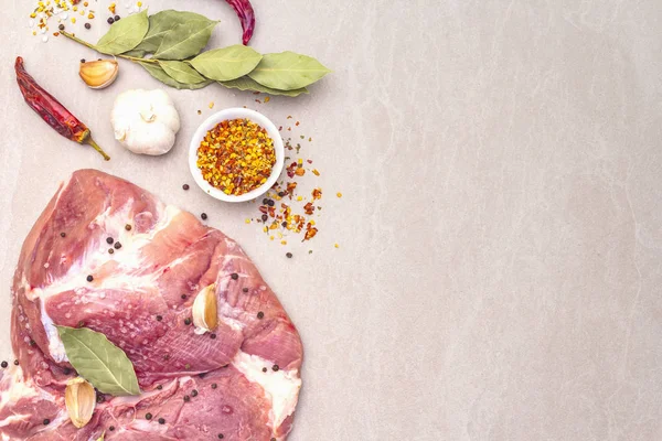 Çiğ domuz omuzu ve baharat. Saha yaprağı, sarımsak. Bir taş arkaplanda, boşluk kopyala, üst görünüm.