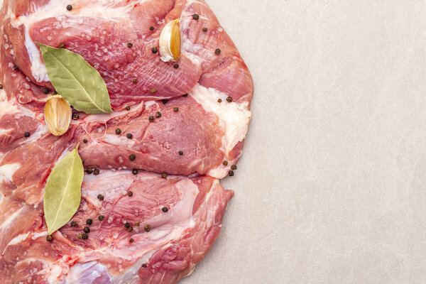 Сырое свиное плечо со специями. Лист лавровый, чеснок. На каменном фоне, скопировать пространство, закрыть
.