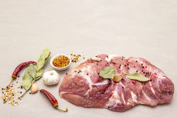 Çiğ domuz omuzu ve baharat. Saha yaprağı, sarımsak. Taş bir arkaplanda, boşluğu kopyala.