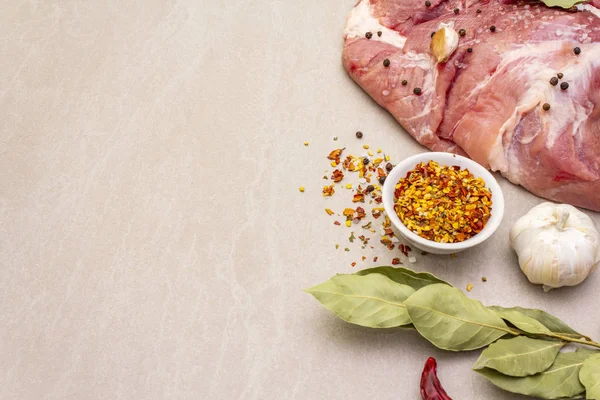 Çiğ domuz omuzu ve baharat. Saha yaprağı, sarımsak. Taş bir arkaplanda, boşluğu kopyala.