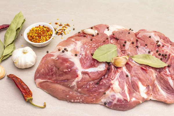 Çiğ domuz omuzu ve baharat. Saha yaprağı, sarımsak. Taş bir arka planda, kapat.