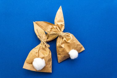 Paskalya tavşanı renkli arka planda yumurta paketleme fikri. Asgari paskalya konsepti, düz yatak, yakın çekim.