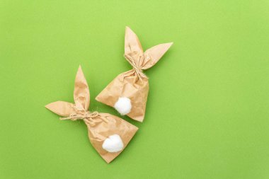 Paskalya tavşanı renkli arka planda yumurta paketleme fikri. Asgari paskalya konsepti, düz yatak, yakın çekim.