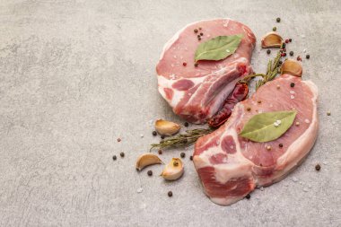 Baharatlı çiğ biftek ve kurutulmuş otlar. Tuz, sarımsak, acı biber, biberiye, arka planda defne yaprağı..