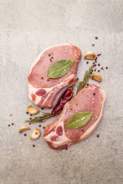 Baharatlı çiğ biftek ve kurutulmuş otlar. Tuz, sarımsak, acı biber, biberiye, arka planda defne yaprağı, üst manzara, kapat..