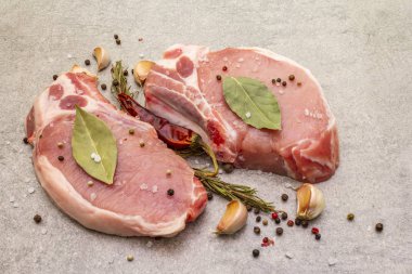 Baharatlı çiğ biftek ve kurutulmuş otlar. Tuz, sarımsak, acı biber, biberiye, arka planda defne yaprağı, kapat..