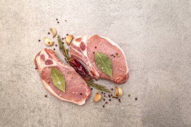 Baharatlı çiğ biftek ve kurutulmuş otlar. Tuz, sarımsak, acı biber, biberiye, arka planda defne yaprağı, üst manzara..