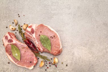 Baharatlı çiğ biftek ve kurutulmuş otlar. Tuz, sarımsak, acı biber, biberiye, arka planda defne yaprağı, üst manzara..