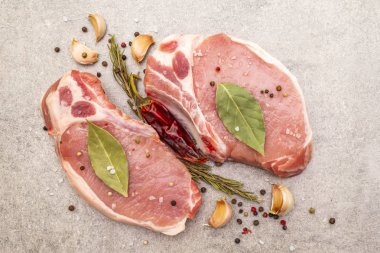 Baharatlı çiğ biftek ve kurutulmuş otlar. Tuz, sarımsak, acı biber, biberiye, arka planda defne yaprağı, üst manzara, kapat..