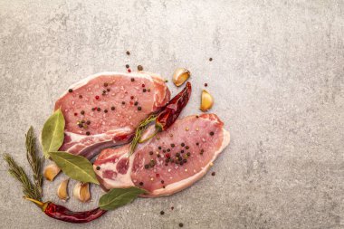 Baharatlı çiğ biftek ve kurutulmuş otlar. Tuz, sarımsak, acı biber, biberiye, arka planda defne yaprağı..