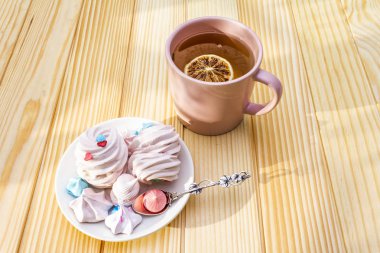 Romantik tatlı kahvaltı konsepti. Yeşil çay, limon, kremalı pasta. Ahşap arka planda.