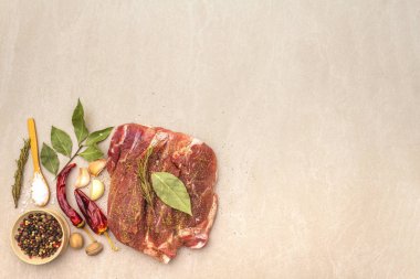 Çiğ domuz omzu. Baharatlar, kuru otlar, sarımsak, biberiye, defne yaprağı, acı biber, hindistan cevizi, biber, tuz. Salamura et için gerekli malzemeler. Taş arkaplan, üst görünüm, kopyalama alanı.