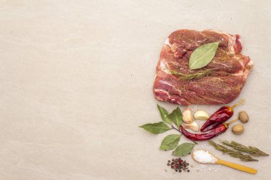 Çiğ domuz omzu. Baharatlar, kuru otlar, sarımsak, biberiye, defne yaprağı, acı biber, hindistan cevizi, biber, tuz. Salamura et için gerekli malzemeler. Taş arkaplan, üst görünüm, kopyalama alanı.