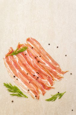 Tütsülenmiş pastırma. Çiğ çizgili, karabiberli ve taştan arka planda taze dereotlu, üst manzara, kapat..