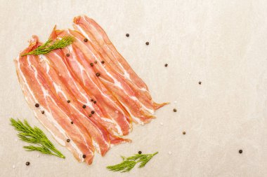 Tütsülenmiş pastırma. Çiğ çizgili, karabiberli ve taştan arka planda taze dereotlu, üst manzara, kapat..
