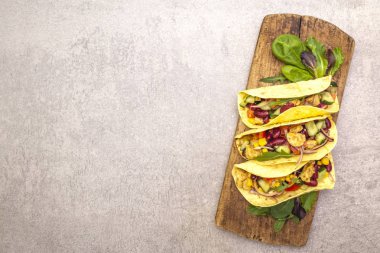 Tavuk etli Meksika tacosu, kırmızı fasulye, tahta tahtada taze sebzeler. Latin Amerika yemekleri, taş arka plan, üst görünüm kopyalama alanı.