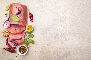 Çiğ domuz filetosu, sebze ve baharatlı. Et pişirme arka planı, taştan arka planda taze kemiksiz biftek, üst manzara, kopyalama alanı.