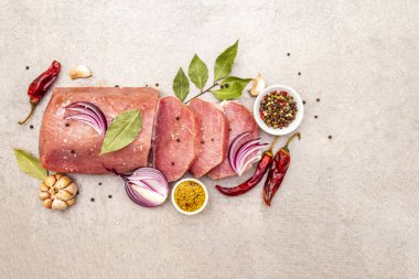 Çiğ domuz filetosu, sebze ve baharatlı. Et pişirme arka planı, taştan arka planda taze kemiksiz biftek, üst manzara, kopyalama alanı.